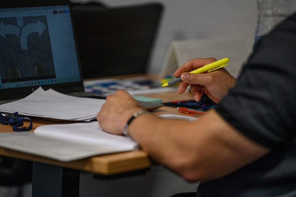 An Airman highlights a transition handout next to a laptop